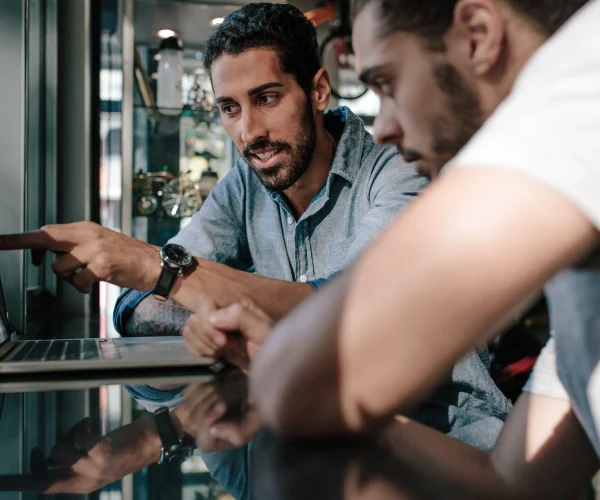 Deux hommes devant un ordinateur dans un magasin.