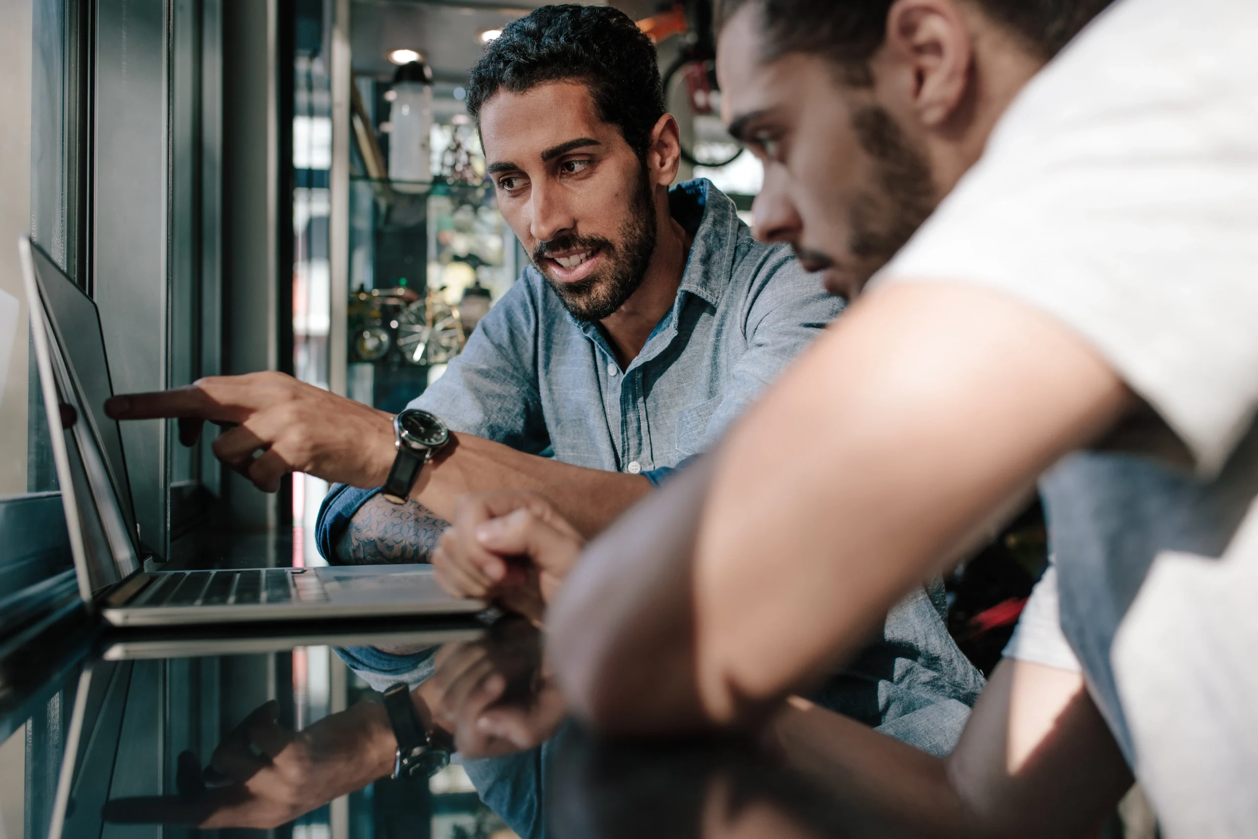 Deux hommes devant un ordinateur dans un magasin.