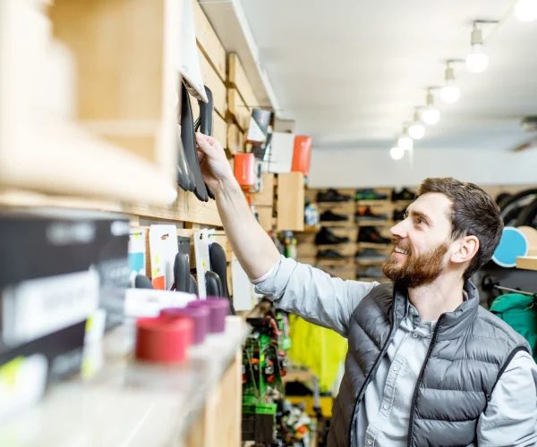 Un vendeur dans son magasin de sport regarde les différents produits.